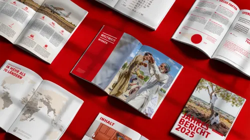 Mehrerer aufgeschlagene Seiten des MSF-Jahresberichts 2025 auf rotem Hintergrund, mit Weltkarte, Infografiken und Reportagefotos aus der humanitären Arbeit.